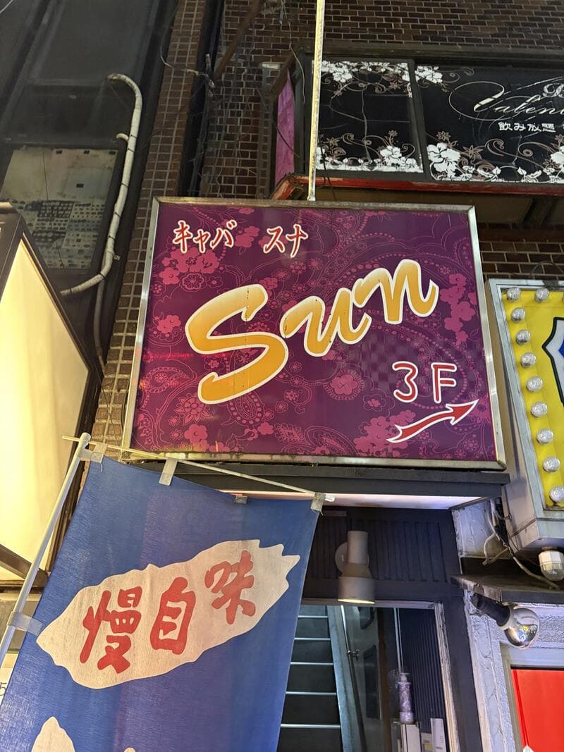銀座のビル壁面に掲げられた「Sun」の紫看板