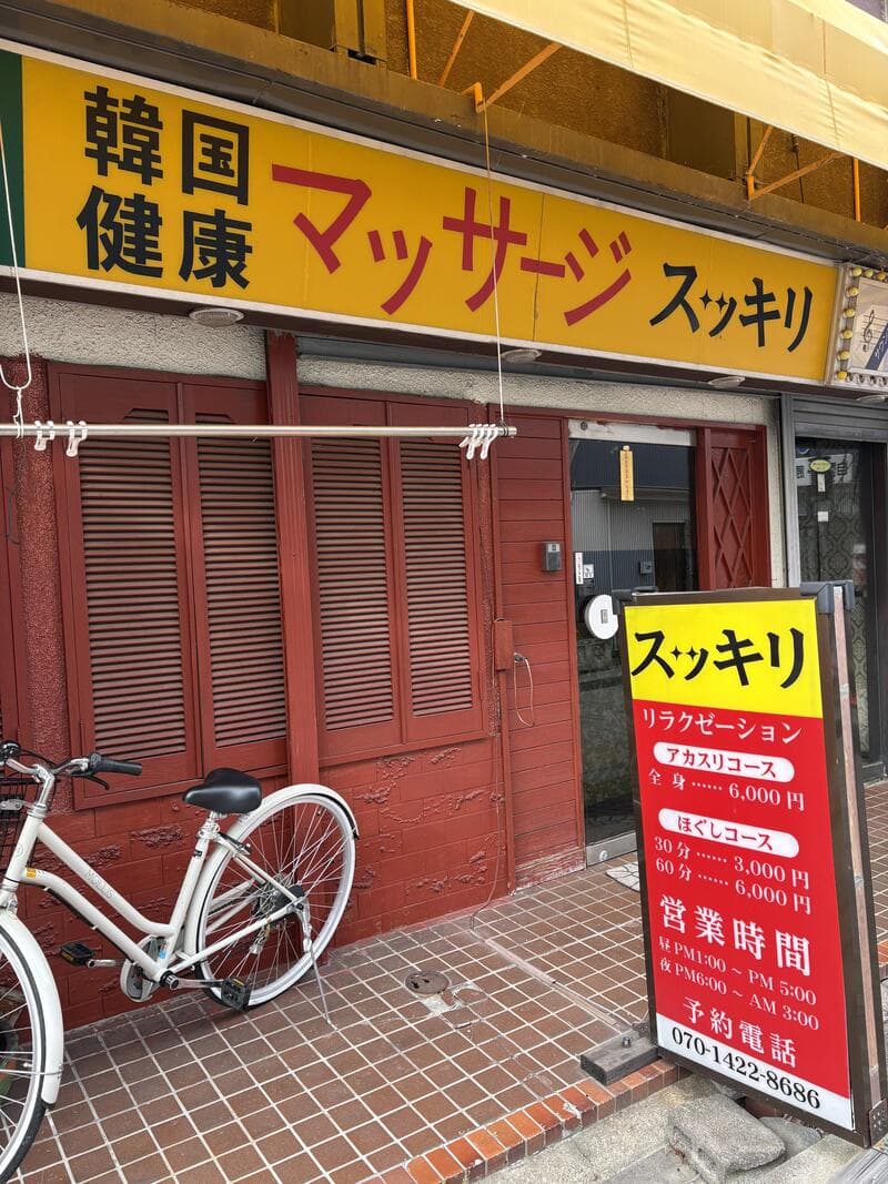 上田市中心部の黄色いファサードに大きく掲げられた「スッキリ」の健康マッサージ看板