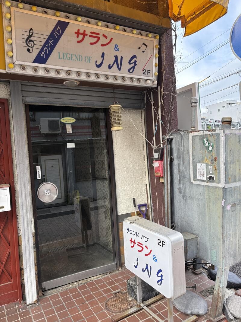 上田市中心部の2階入口に残る「サラン & JNG」の電飾看板