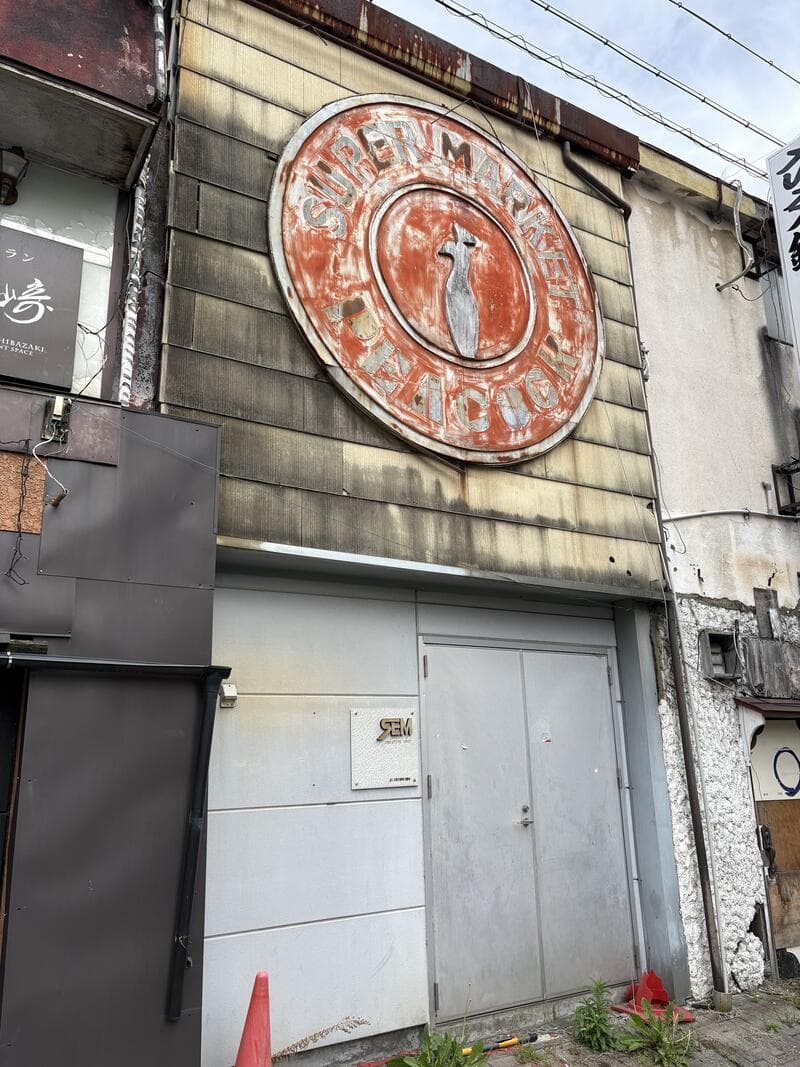 上田市中心部の外壁に残る円形の「BAR COCKTAIL」跡看板