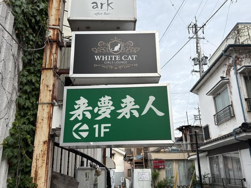 「WHITE CAT」と「来夢来人」が並ぶ上田市中心部の路地看板