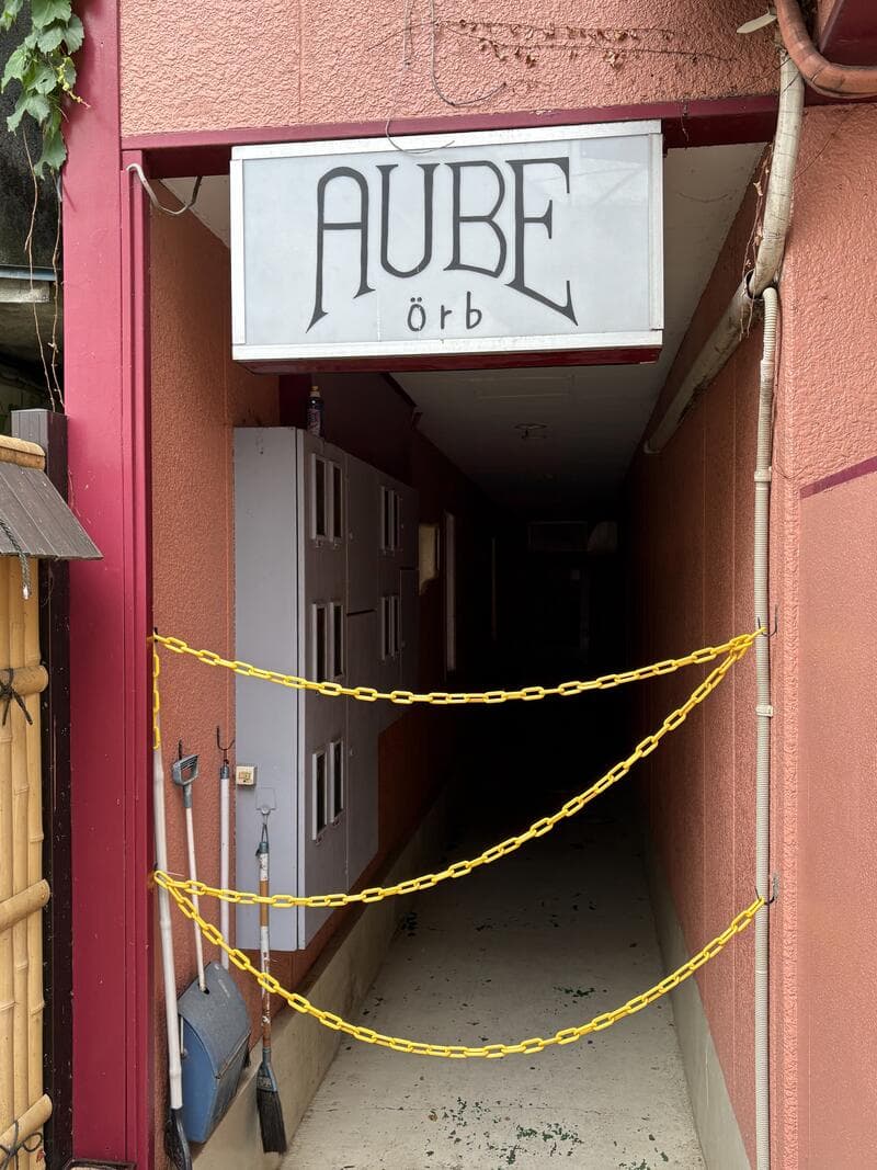 ピンクの入口奥に残る「AUBE orb」の白い袖看板