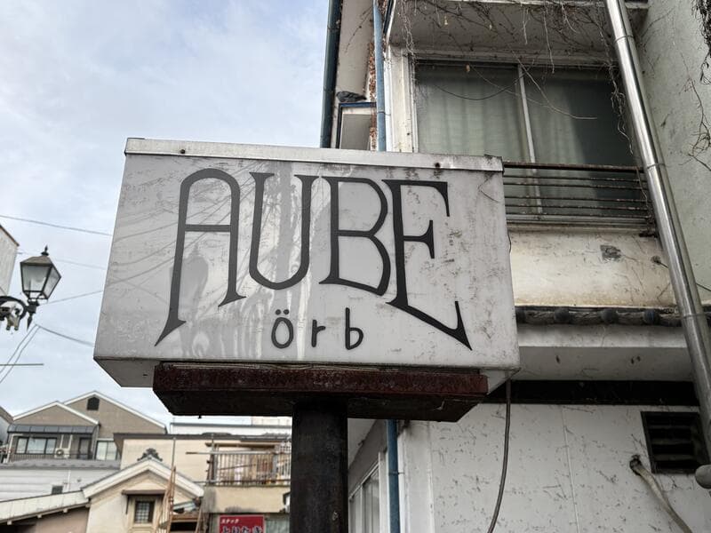 上田市中心部の外壁に突き出す「AUBE orb」の古びた袖看板