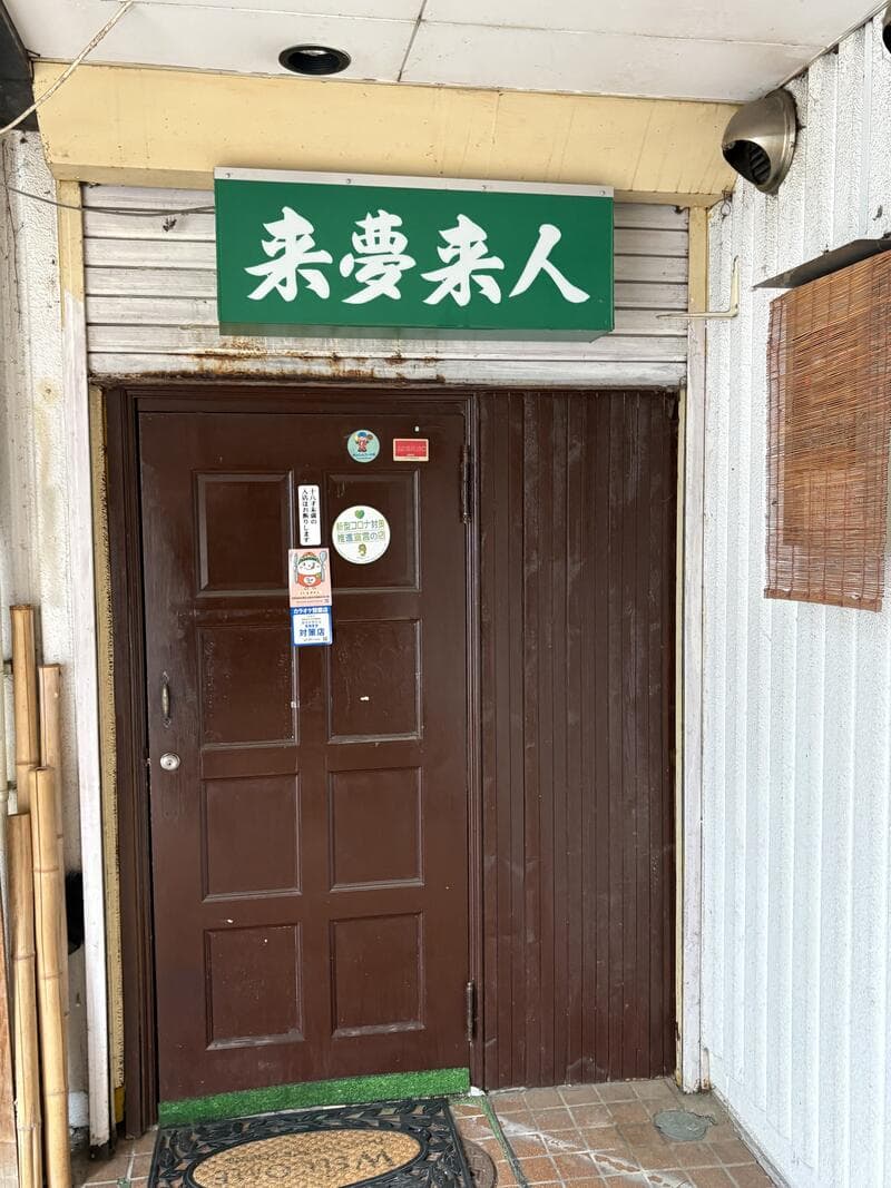 上田市中心部の扉上に掲げられた緑の「来夢来人」入口看板