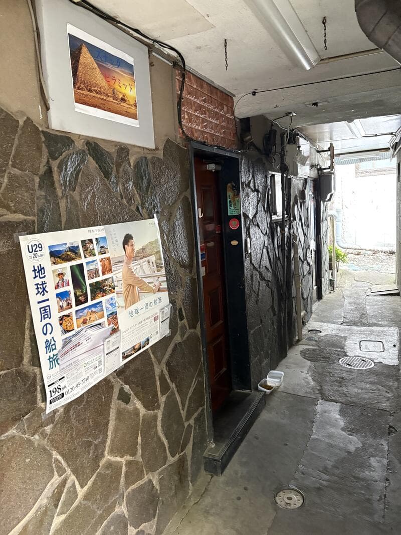 細い通路の奥に見える「ピラミッド」の壁面看板