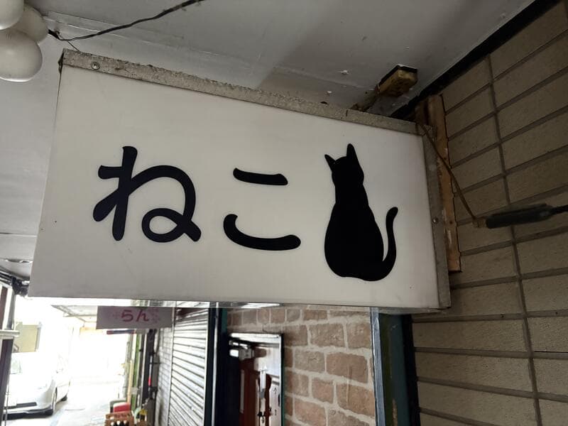 黒猫シルエットを添えた白い「ねこ」看板