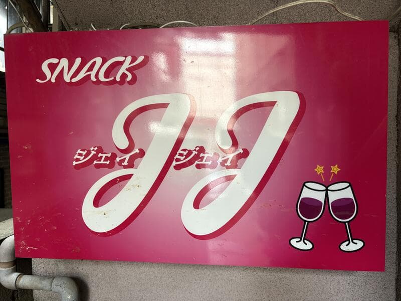 ピンク地にグラスのイラストを添えた「SNACK JJ」看板