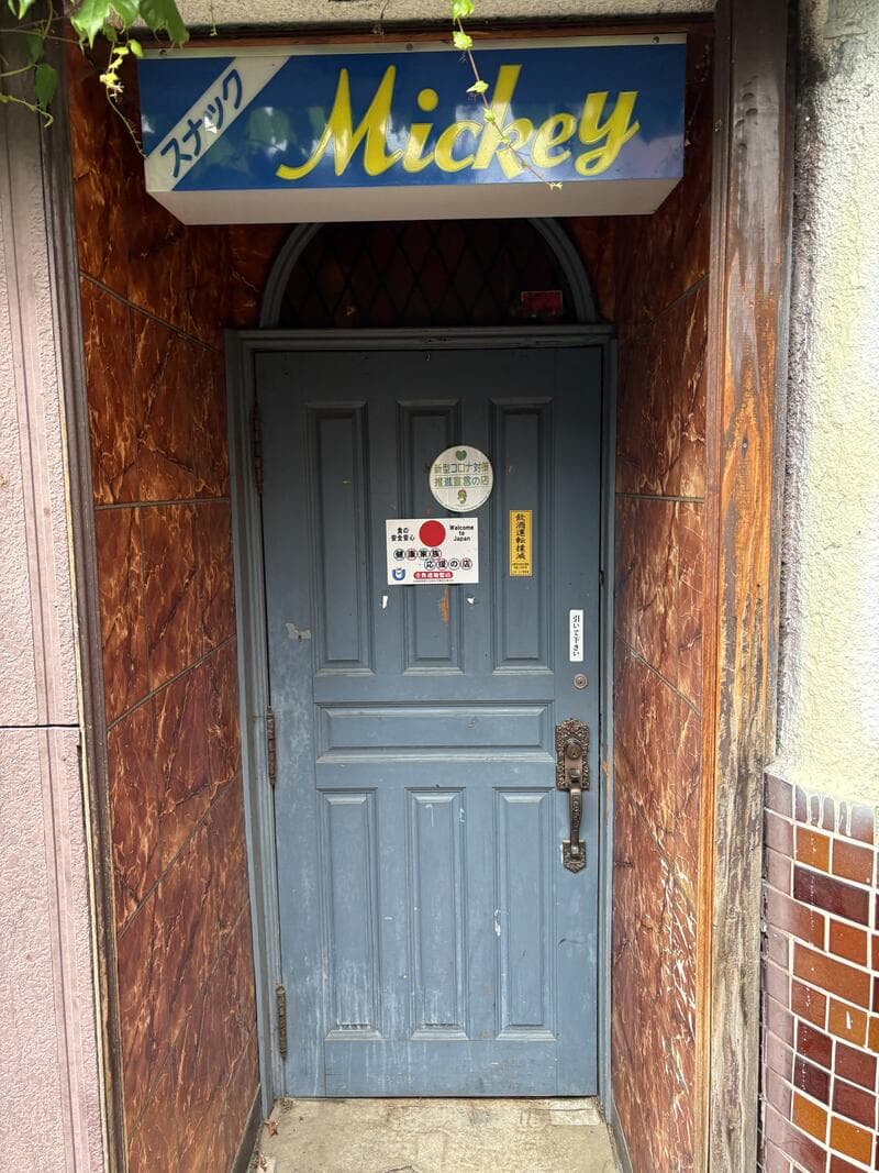 蔦の絡む入口に残る青い「メキシカン Mickey」看板