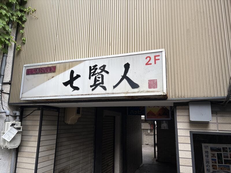 2階へ誘う白い「七賢人」看板