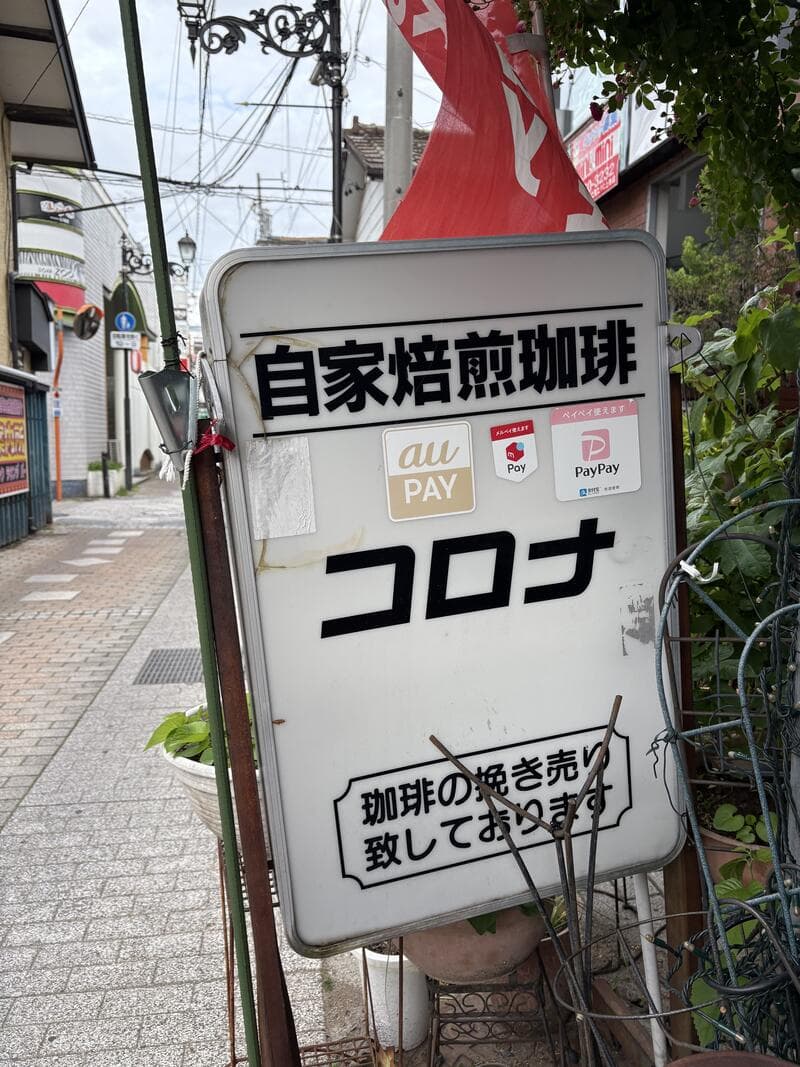 路地に立つ「自家焙煎珈琲 コロナ」の白い看板