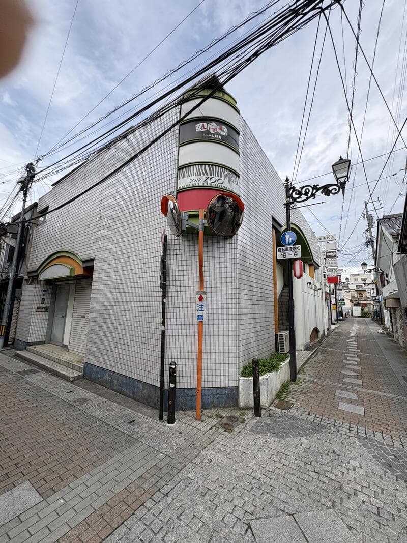 角地の外壁に連なる「ZOO」周辺の帯看板風景