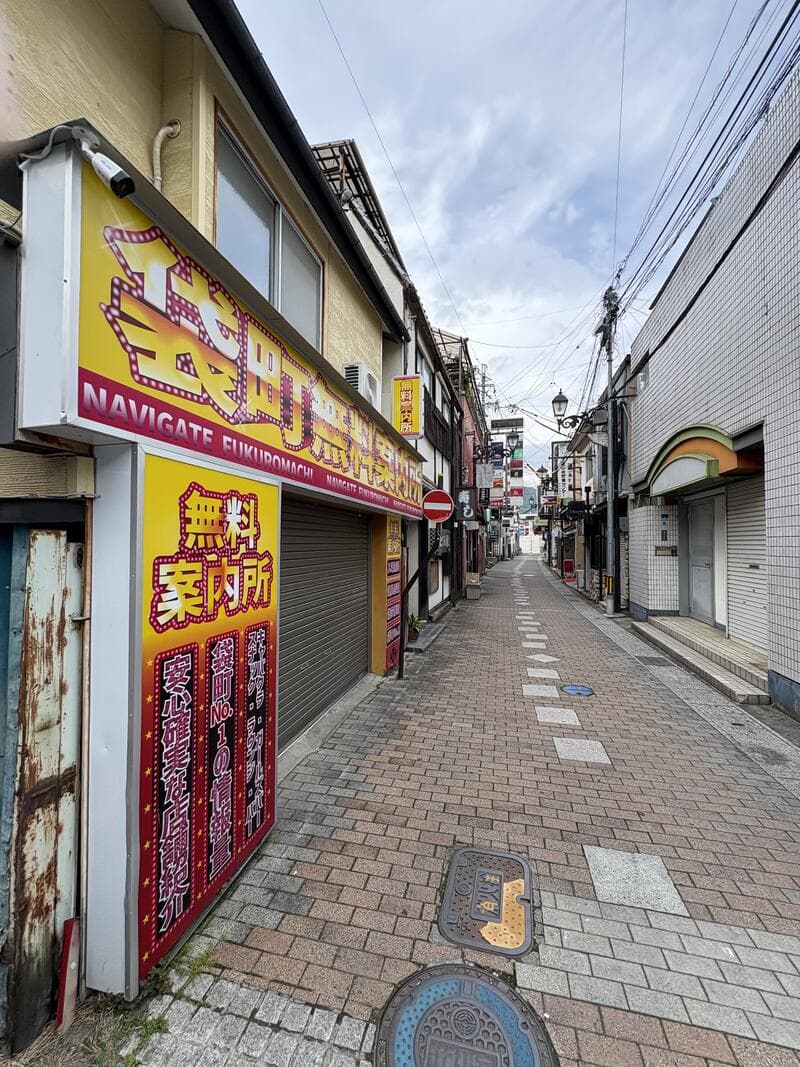 黄色と赤の大きな面板が目立つ「無料案内所」の看板