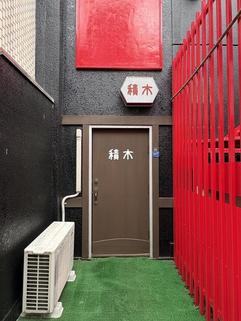 赤い格子の奥に続く「積木」の入口表示
