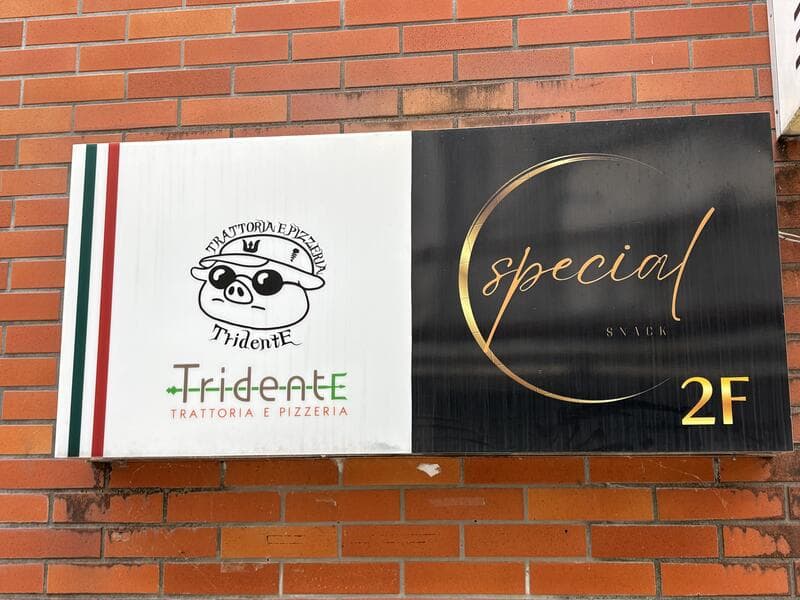 レンガ壁に並ぶ「Tridente」と「special」の2階看板