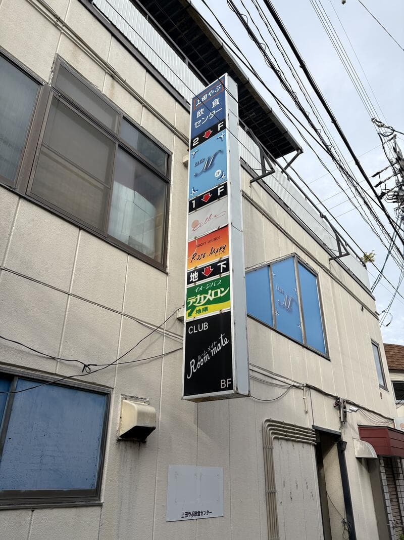 青いビル集合看板に複数店名が並ぶ上田市中心部の外壁看板