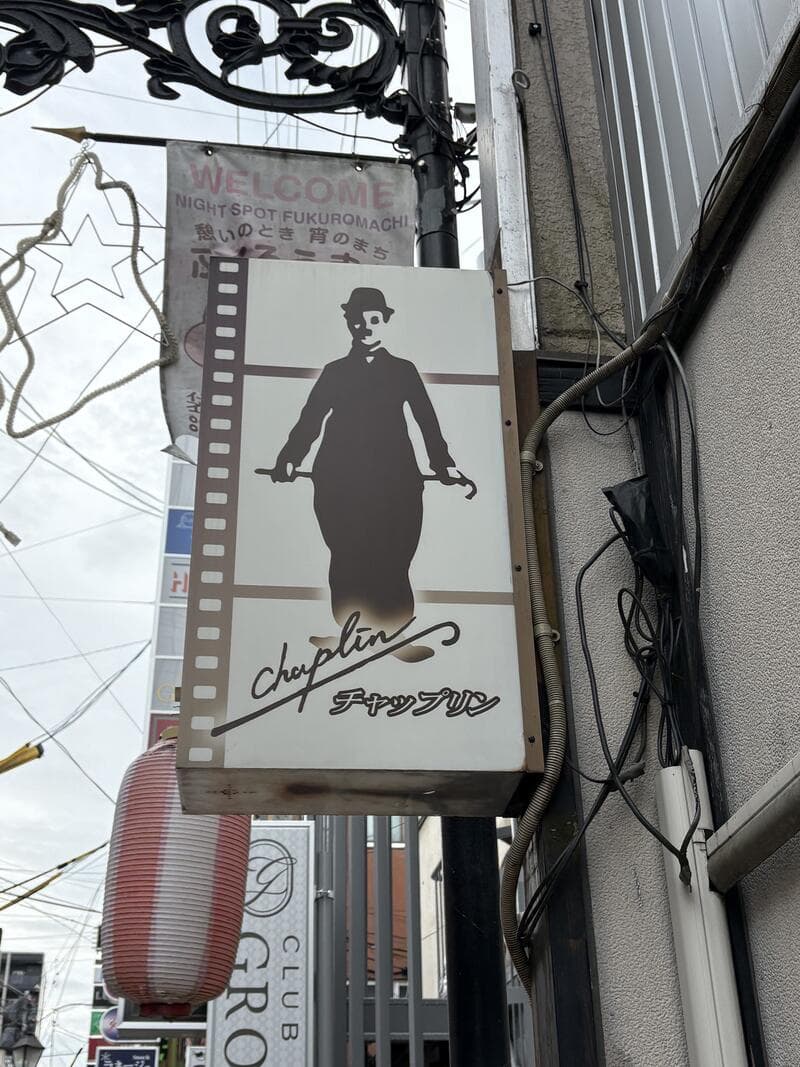 映画フィルムと人影を描いた「チャップリン」看板