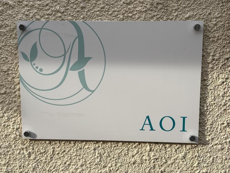 白いアクリル板に薄緑のロゴを入れた「AOI」表札看板