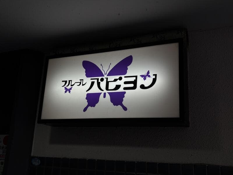 紫の蝶を大きく描いた「フルフル ハピョン」看板