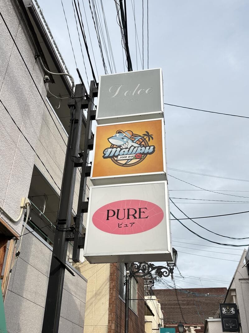 「malibu」「PURE」などが縦に重なる外壁集合看板