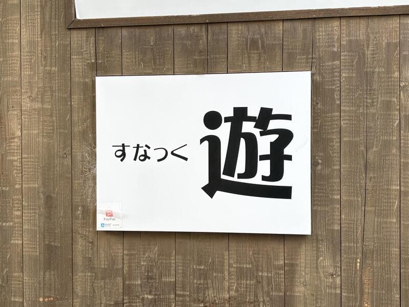 白地に大きな一文字を置いた「すなっく 遊」看板