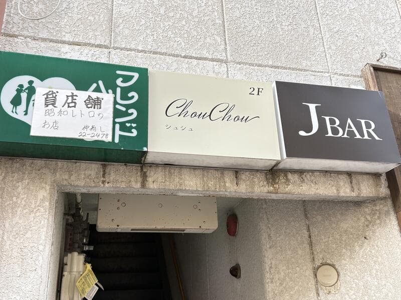 入口上に並ぶ「フレンドハウス」「ChouChou」「J BAR」の集合看板