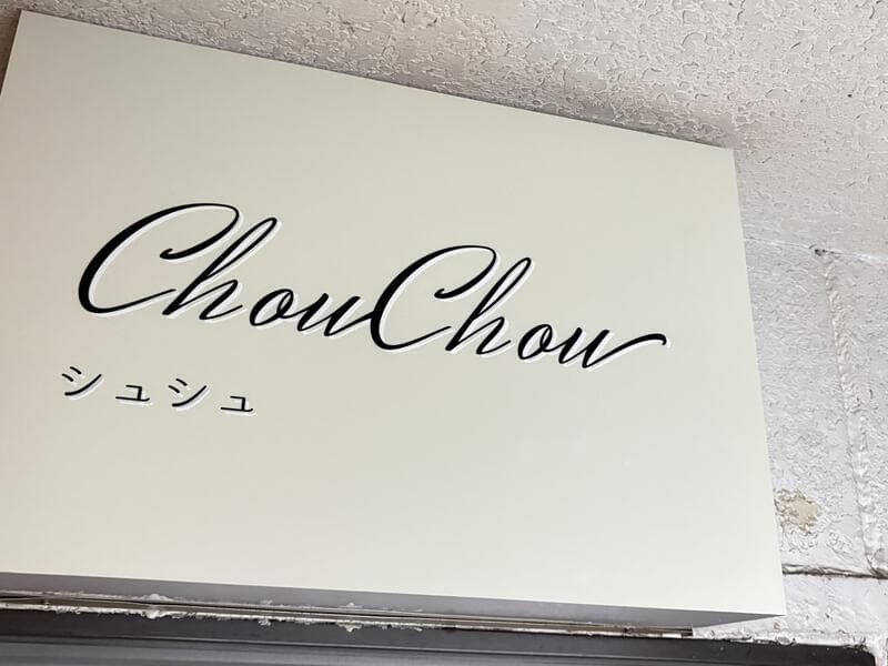 白い面板に筆記体を置いた「ChouChou」看板