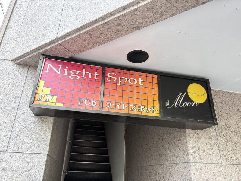 階段入口に掲げられた横長の「Night Spot Moon」看板