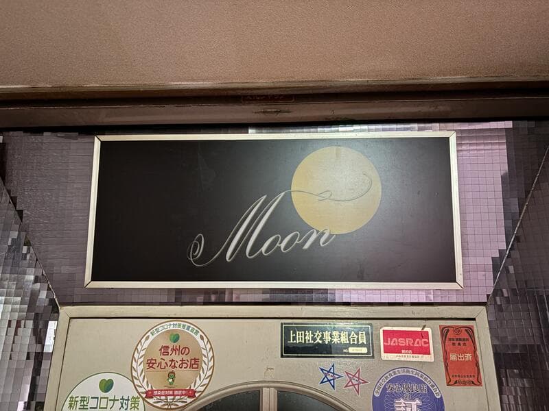 入口ガラス上に掲げられた黒い「Moon」看板
