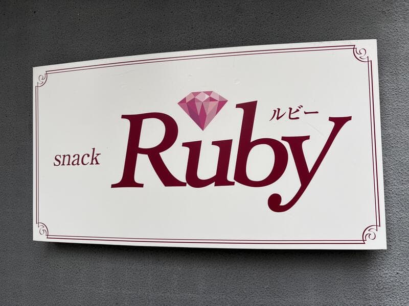 白地に赤い宝石ロゴを添えた「snack Ruby」壁面看板