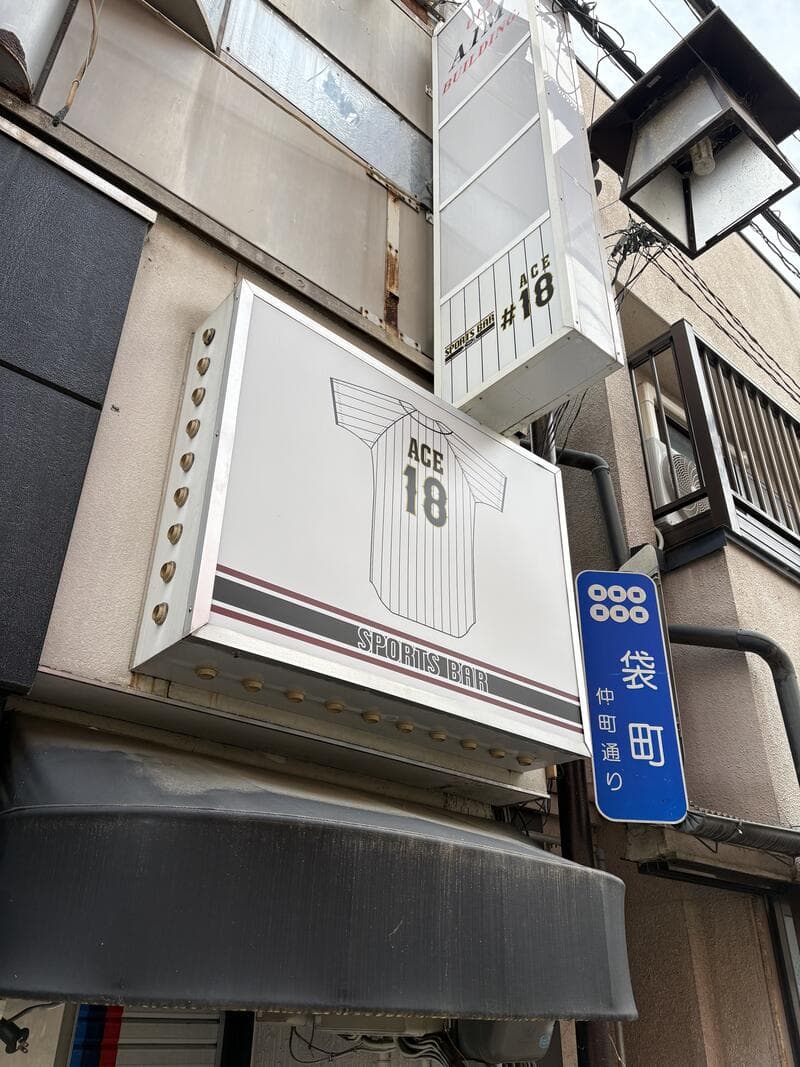 白い箱看板に翼の意匠を入れた「ACE 18」看板
