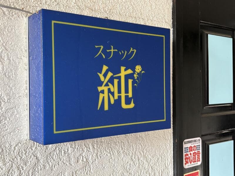 青地に金文字の「スナック 純」箱看板