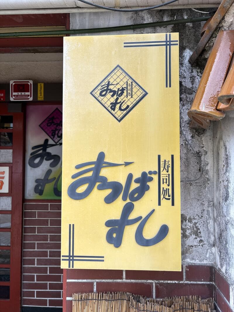 黄色い暖簾型の「寿司処 まつばすし」看板