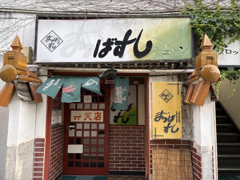 小さな店構えに重なる「まつばすし」看板群