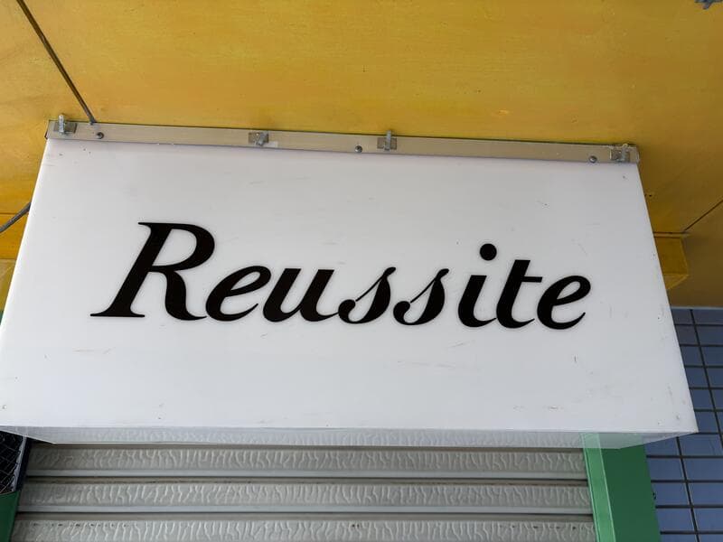 白い庇に筆記体の「Reussite」看板