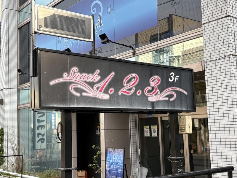 黒地にピンク文字の「Snack 1.2.3」3F 看板