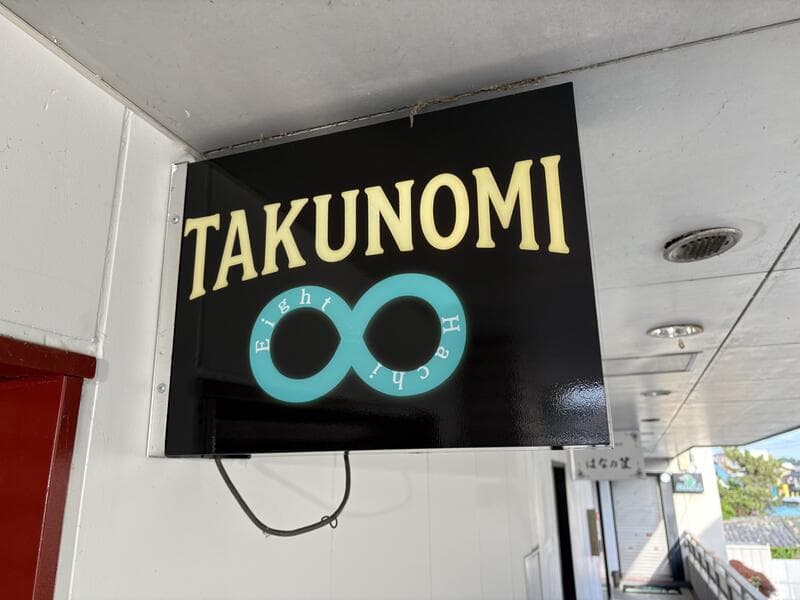 黒地に∞マークの「TAKUNOMI」看板