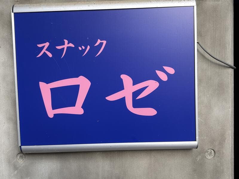 青地にピンク文字の「スナック ロゼ」看板