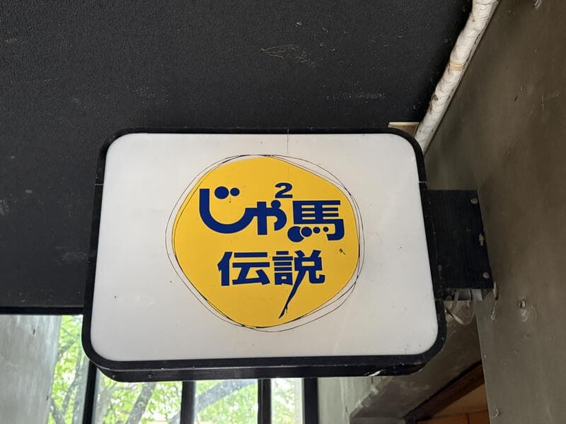 黄色い円ロゴの「じゅ馬 伝説」看板