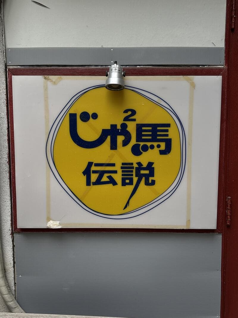 黄色い円ロゴの「じゃ馬伝説」入口看板