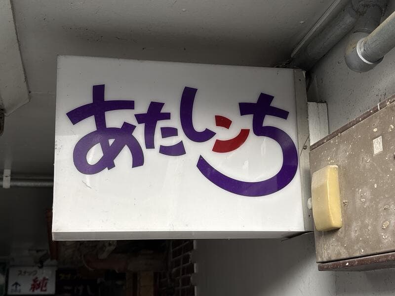 白地に紫文字の「あたしンち」看板