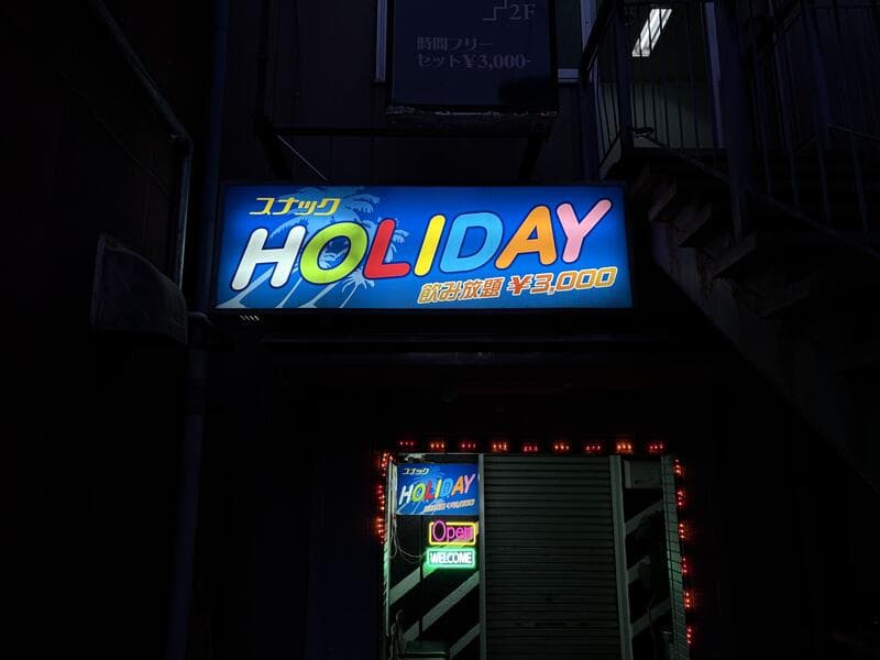 青く光る「スナック HOLIDAY」看板
