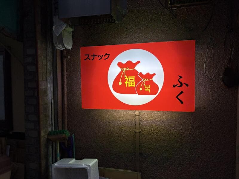 壁面に灯る「スナック ふく」赤看板