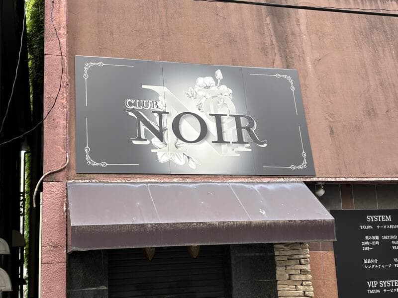 富山・桜木町の茶色い外壁に埋め込まれた「NOIR」のプレート