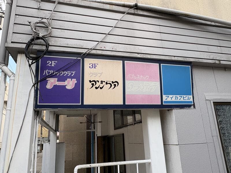 富山・桜木町の入口上に並ぶ青と桃色の簡易案内板 アーサ