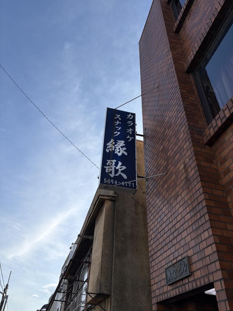 小岩の夕空に突き出した『縁歌』の縦長袖看板